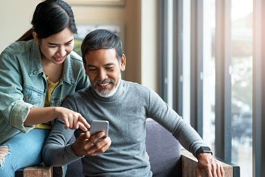 A man and woman looking at a phone.