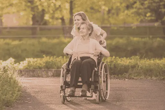 A woman in a wheelchair with another person.