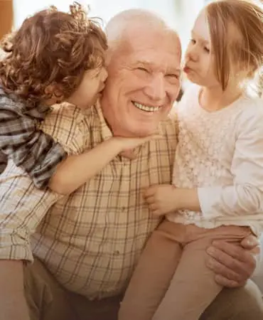 A man with two young children sitting on his lap.